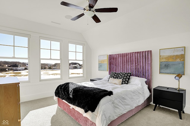 bedroom with ceiling fan, light colored carpet, visible vents, baseboards, and vaulted ceiling