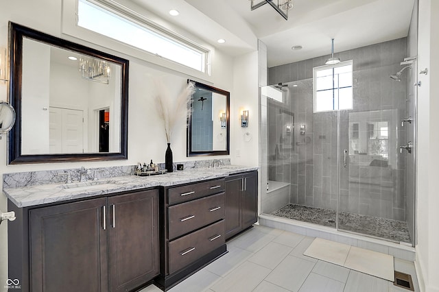 full bath featuring double vanity, a shower stall, visible vents, and a sink