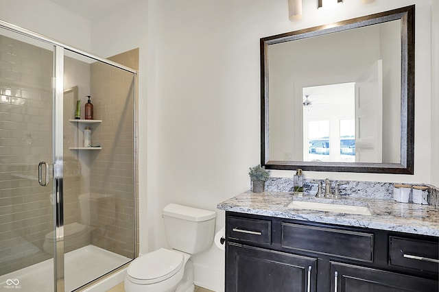 bathroom with a stall shower, vanity, and toilet