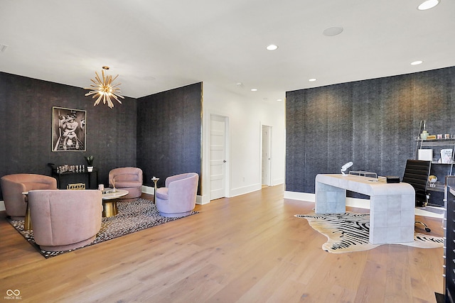 living area with an accent wall, wood finished floors, and recessed lighting