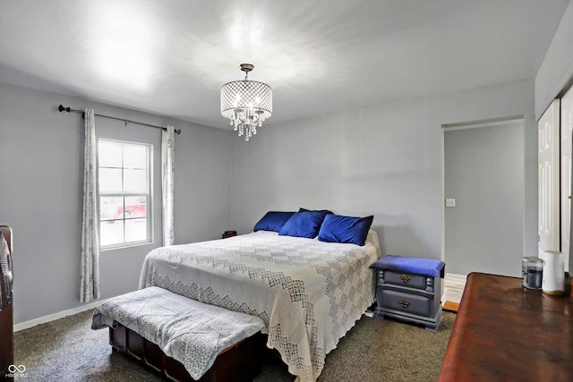 carpeted bedroom featuring baseboards, a closet, and an inviting chandelier