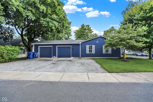 ranch-style home with driveway, a front lawn, and an attached garage