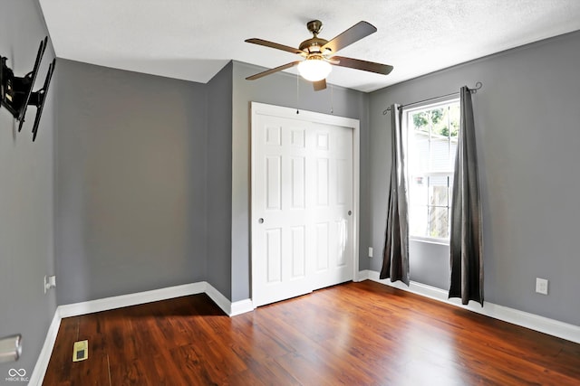 unfurnished bedroom featuring a closet, wood finished floors, visible vents, and baseboards