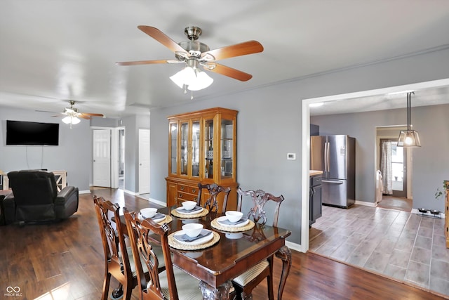 dining room featuring ceiling fan, wood finished floors, and baseboards