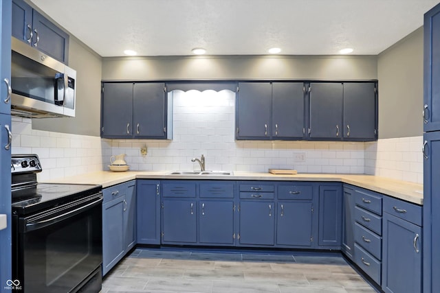 kitchen featuring light countertops, stainless steel microwave, backsplash, electric range, and a sink