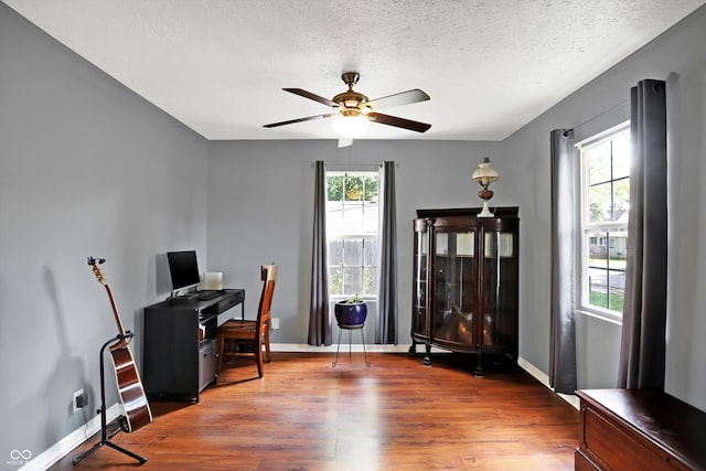 office space featuring a textured ceiling, ceiling fan, wood finished floors, and baseboards