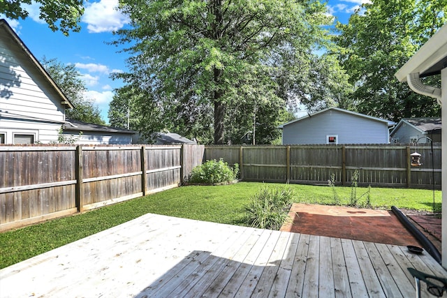 deck featuring a fenced backyard, a lawn, and a patio