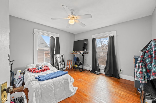 bedroom with baseboards, ceiling fan, and hardwood / wood-style floors