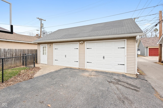 detached garage featuring fence