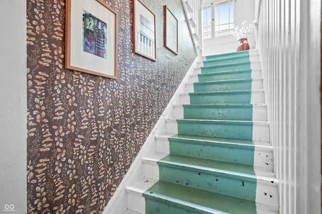 staircase with wallpapered walls