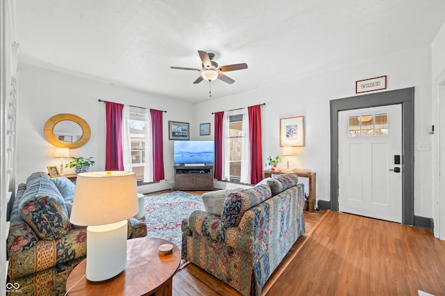 living area with ceiling fan and wood finished floors