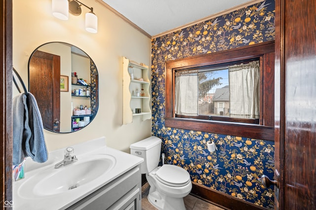 bathroom with ornamental molding, vanity, and toilet