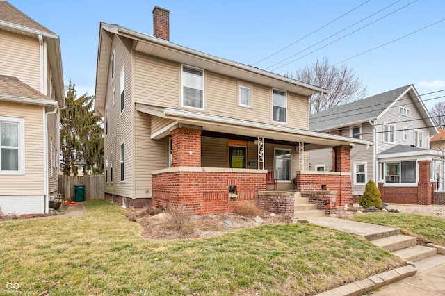 view of front of home featuring covered porch, a chimney, and a front lawn