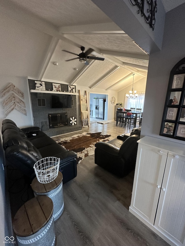 living room featuring lofted ceiling with beams, ceiling fan with notable chandelier, and wood finished floors