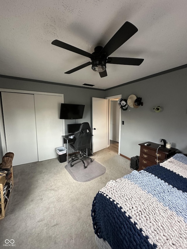 bedroom featuring light carpet, a closet, a textured ceiling, and crown molding