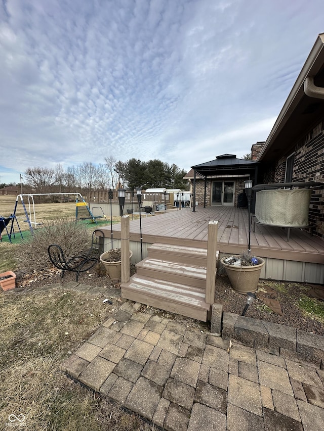 wooden terrace featuring playground community, fence, and a gazebo