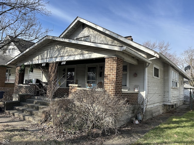 view of front of home with brick siding and a porch