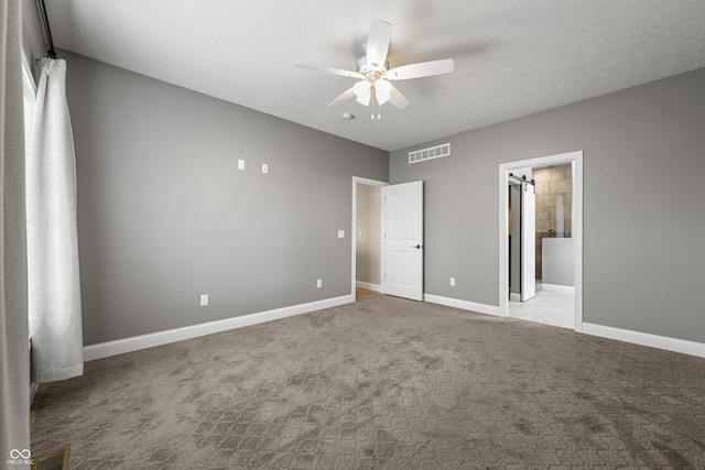 unfurnished bedroom featuring carpet floors, baseboards, visible vents, and ensuite bathroom