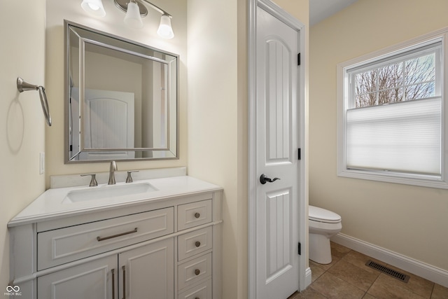 bathroom with baseboards, visible vents, toilet, tile patterned flooring, and vanity