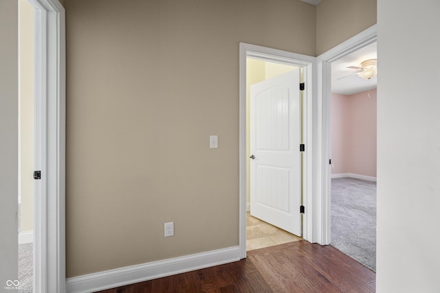 interior space featuring wood finished floors, a ceiling fan, and baseboards