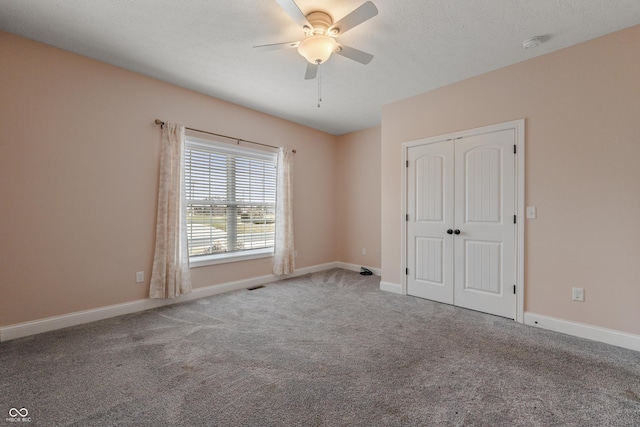 spare room with a ceiling fan, carpet flooring, and baseboards