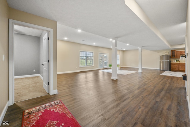 unfurnished living room with decorative columns, baseboards, dark wood-style flooring, and recessed lighting