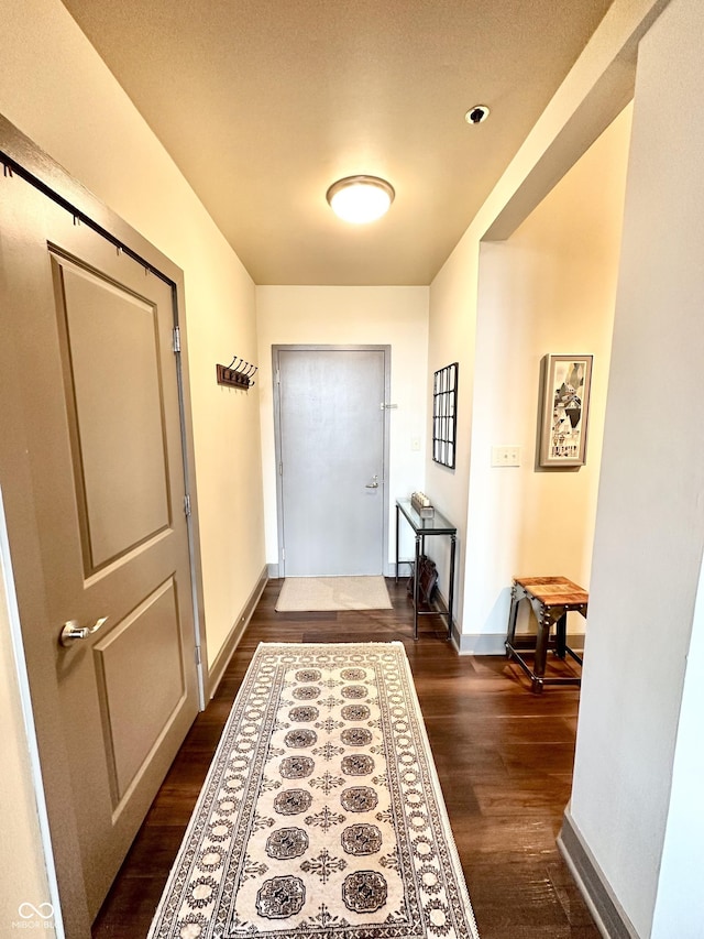 doorway to outside with baseboards and dark wood-style flooring