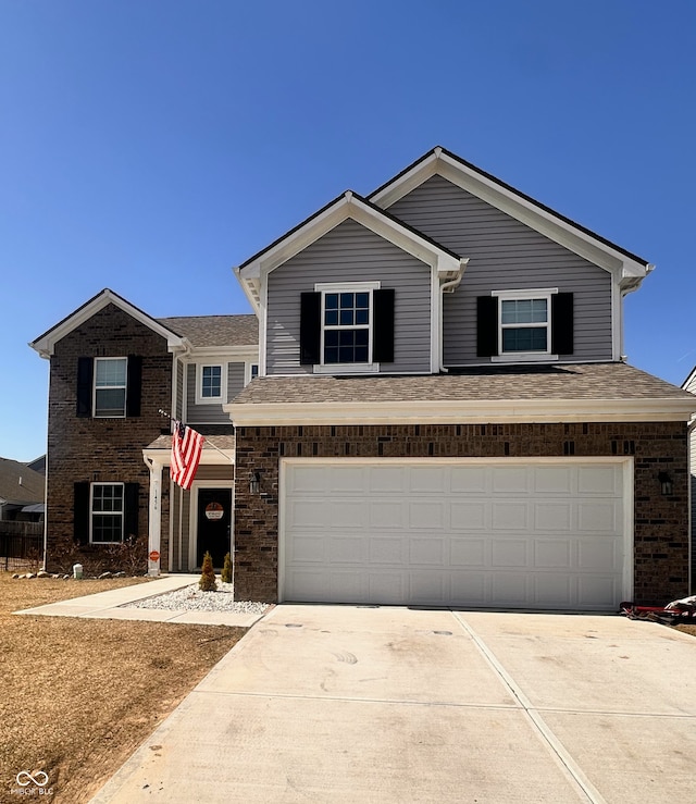 traditional home featuring concrete driveway, an attached garage, brick siding, and roof with shingles