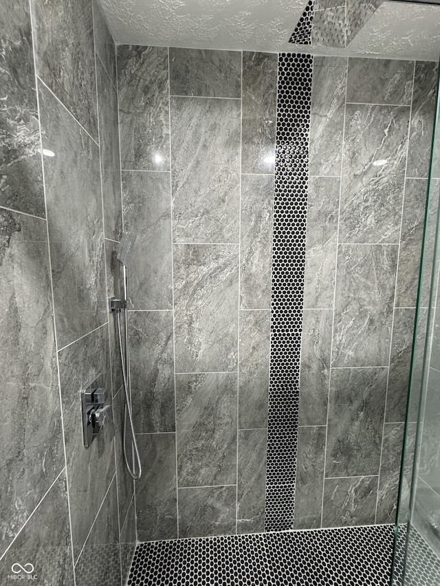 bathroom featuring a textured ceiling and a shower stall