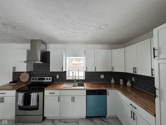 kitchen with marble finish floor, stainless steel appliances, a sink, wall chimney range hood, and butcher block countertops