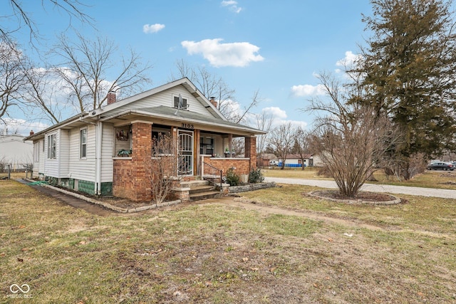 bungalow-style home featuring a chimney, a porch, and a front yard