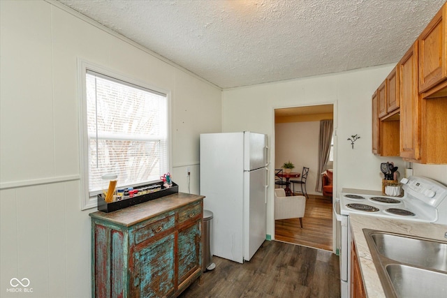 kitchen featuring a textured ceiling, white appliances, light countertops, brown cabinets, and dark wood finished floors