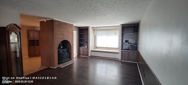 unfurnished living room featuring a textured ceiling, radiator heating unit, dark wood finished floors, and baseboards