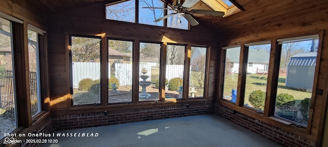 unfurnished sunroom with a wealth of natural light, vaulted ceiling with skylight, and ceiling fan