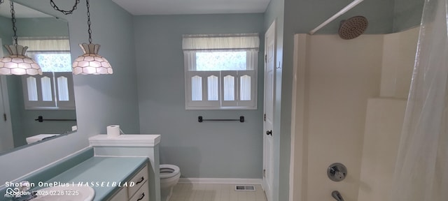 full bath featuring visible vents, toilet, shower / bath combo with shower curtain, vanity, and baseboards