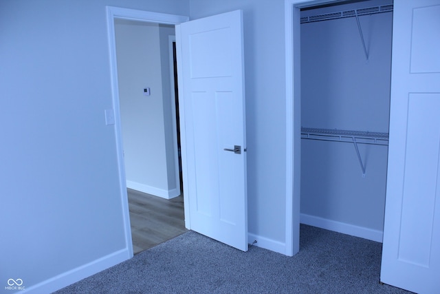 unfurnished bedroom with carpet, baseboards, and a closet