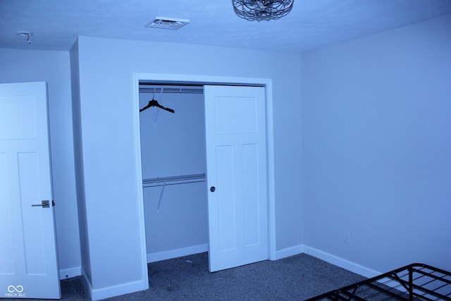 unfurnished bedroom with a closet, carpet flooring, visible vents, and baseboards