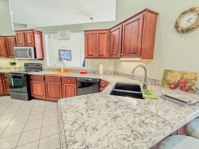 kitchen with light tile patterned floors, a peninsula, black appliances, a kitchen bar, and a sink