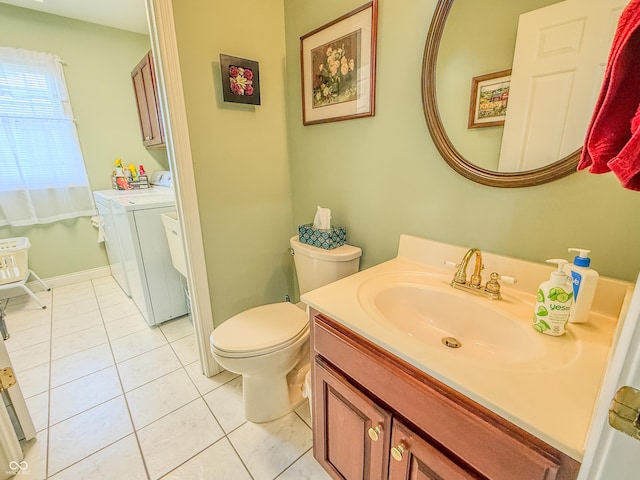 bathroom featuring toilet, washing machine and dryer, tile patterned flooring, and vanity