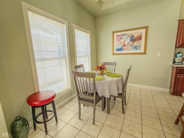 dining room with light tile patterned flooring and baseboards