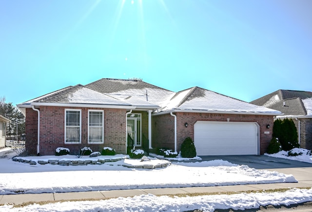 view of front of property featuring an attached garage, driveway, and brick siding