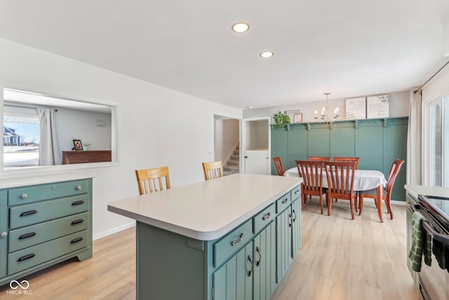 kitchen featuring range with electric cooktop, a center island, light wood-style floors, green cabinets, and light countertops