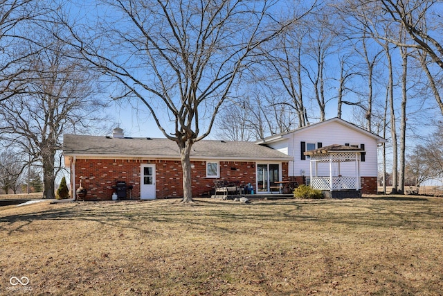 back of house featuring a yard and brick siding