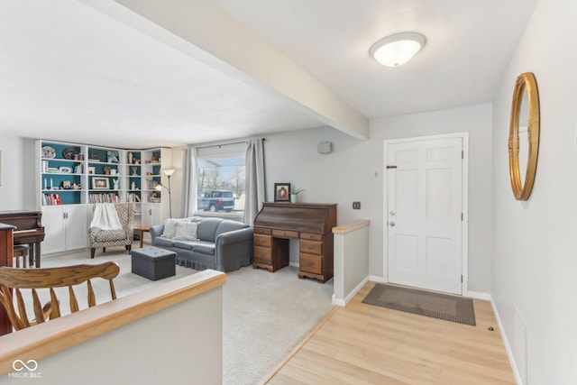 foyer with beam ceiling, baseboards, and wood finished floors