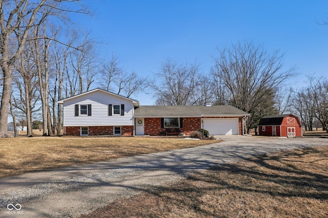 split level home with a front lawn, driveway, a barn, an attached garage, and brick siding