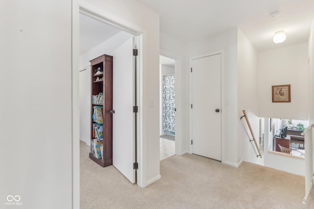 corridor featuring an upstairs landing and carpet flooring