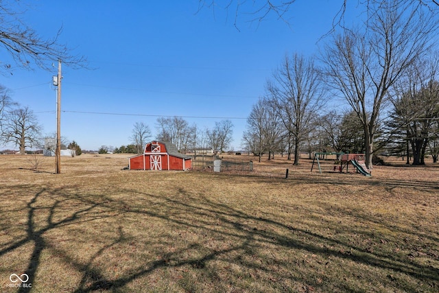 view of yard with a barn, an outdoor structure, and a playground