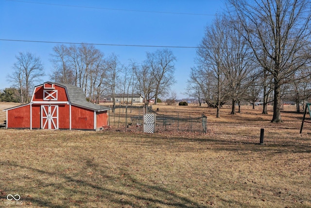 view of yard with an outbuilding, a barn, and fence