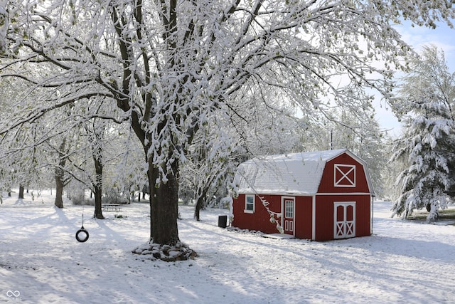 snow covered structure featuring a barn and an outdoor structure