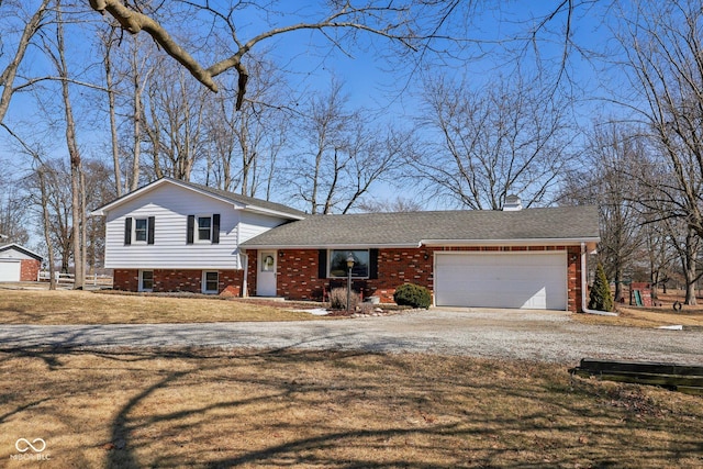 split level home with brick siding, a shingled roof, gravel driveway, a front yard, and a garage